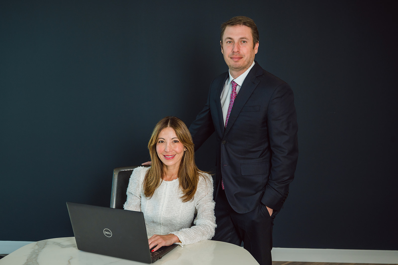 Business professionals posing with laptop computerRetry