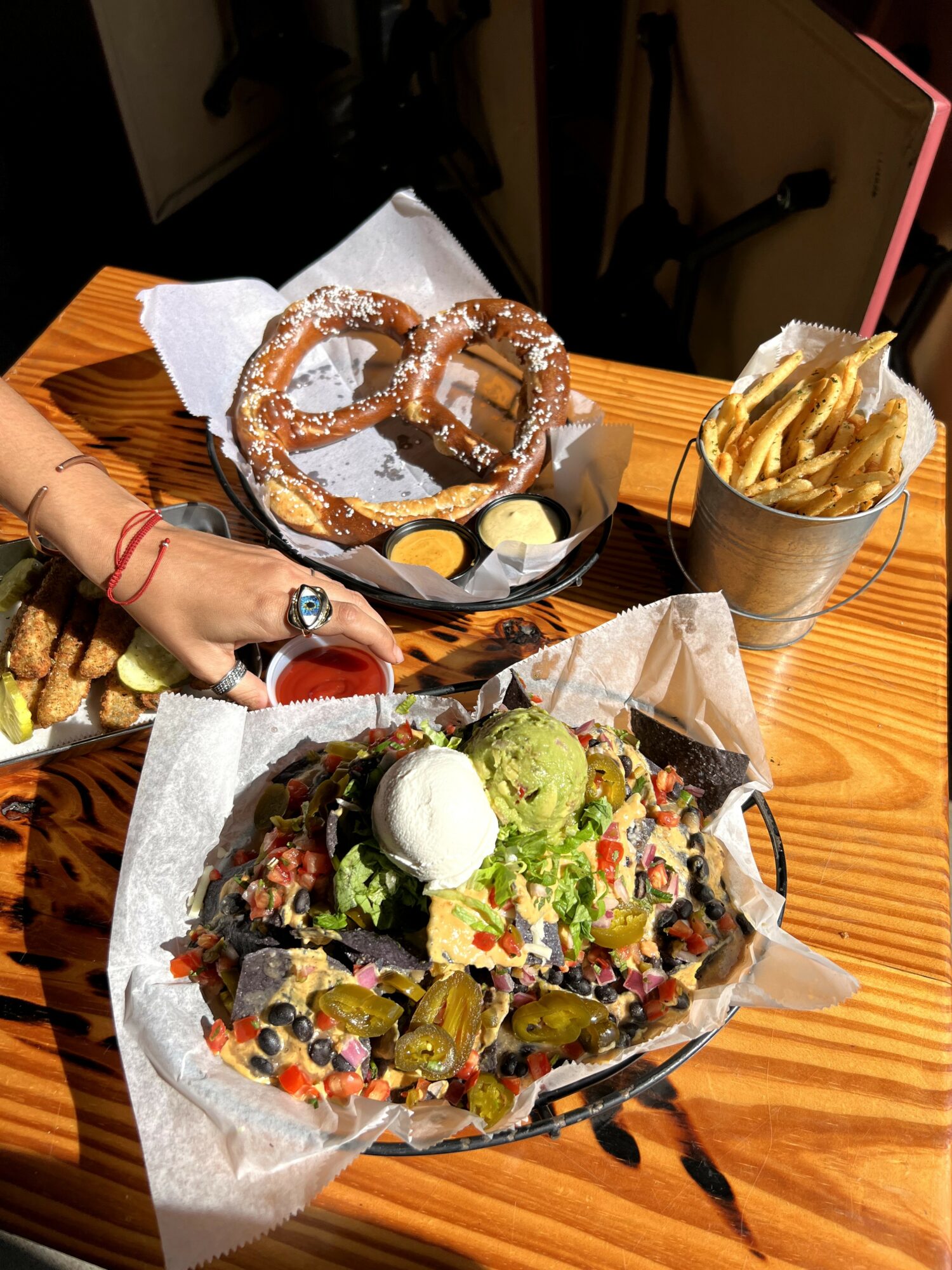 Plate with salad, scoop of green ice cream, and various vegetables on parchment paper, on a wooden table.