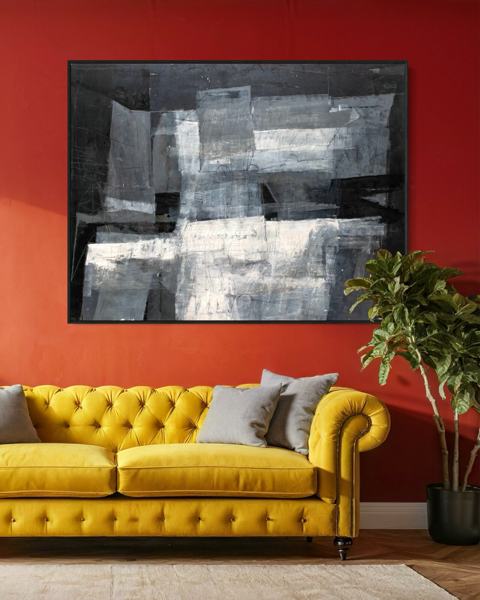 Living room with a yellow tufted sofa, gray pillows, a large abstract painting, and a potted plant against a red wall.