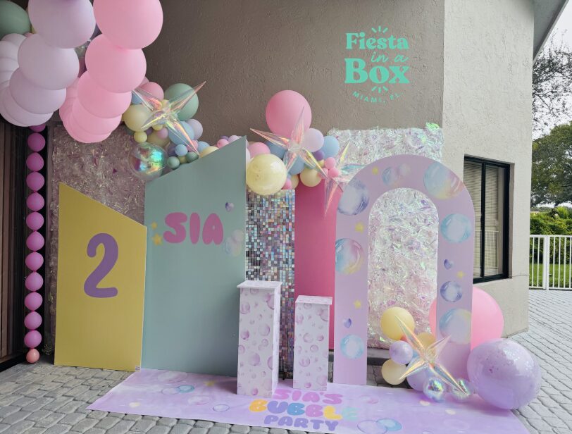 Decorative backdrop with balloons, large numbers, and pastel colors for a celebration.