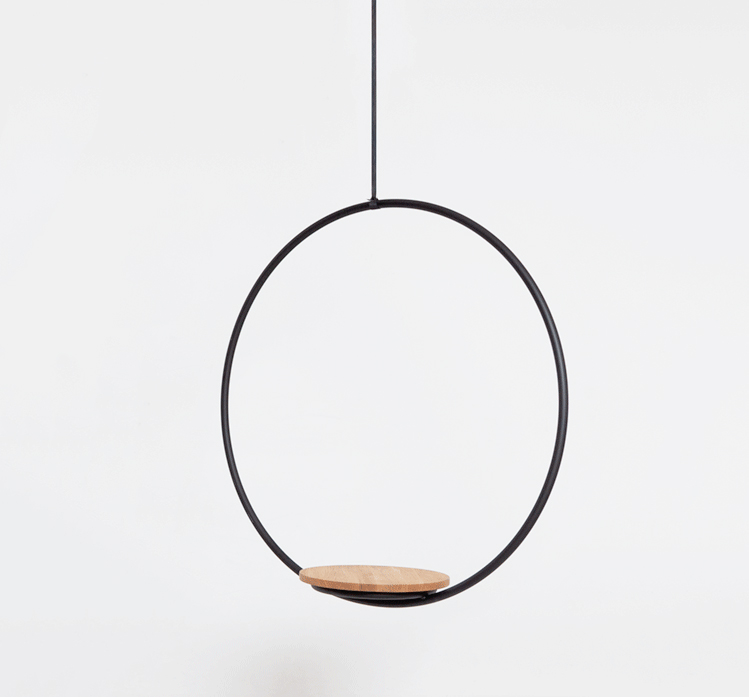 Hanging circular frame with a wooden platform inside, suspended by a thin cord against a plain background.