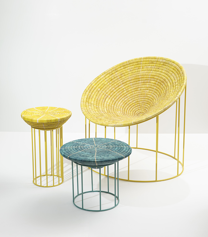 Three colorful wireframe stools with woven seats in yellow, blue, and yellow, arranged against a plain white background.
