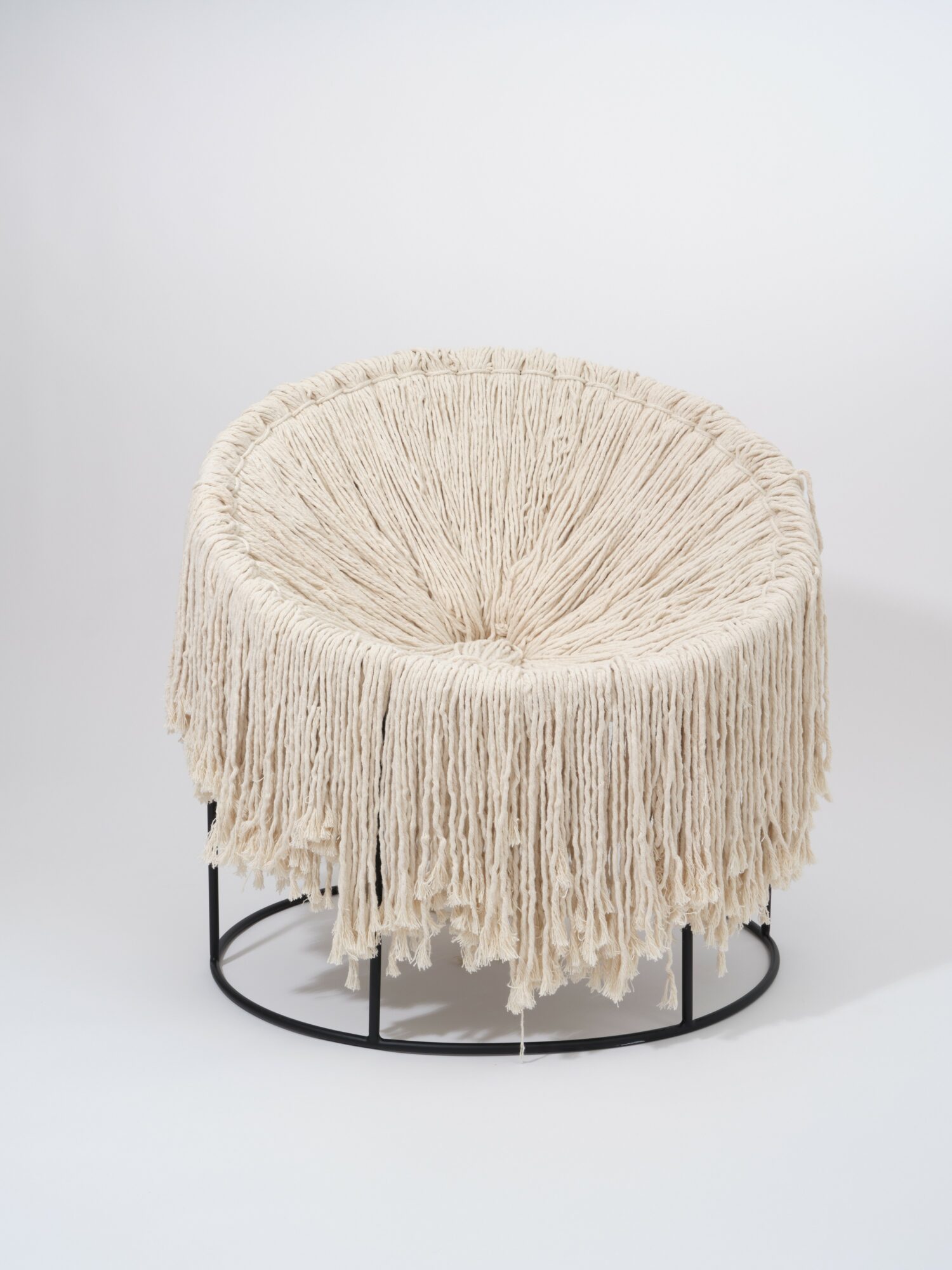Round chair with cream-colored fringes and black metal base, set against a plain white background.