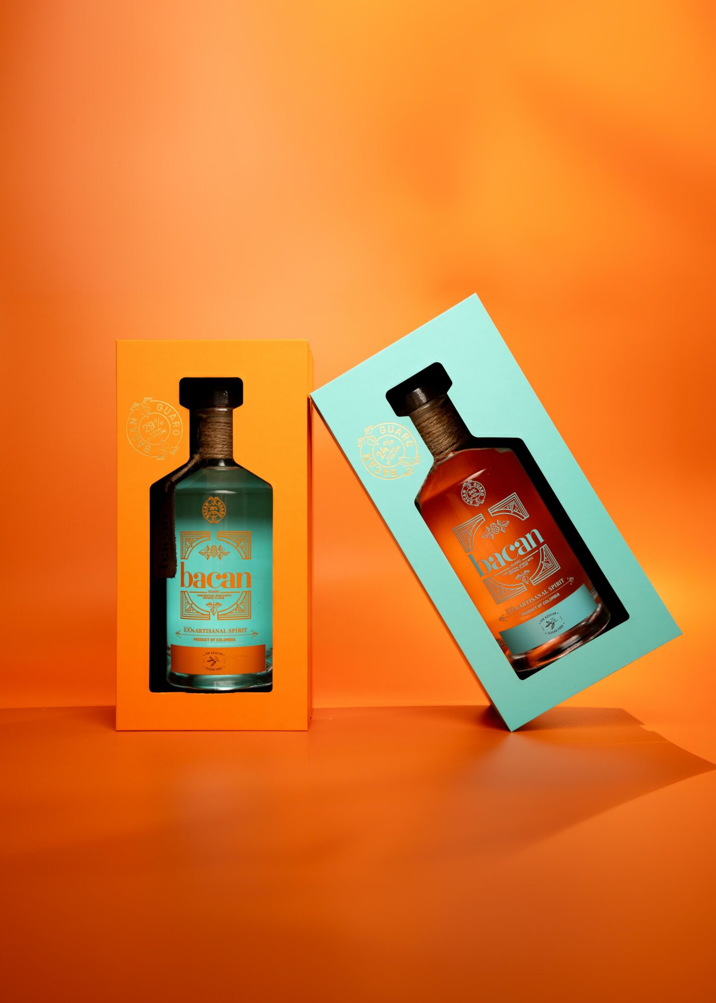 Two bottles in colorful boxes on an orange background, one in an orange box and the other in a blue box.