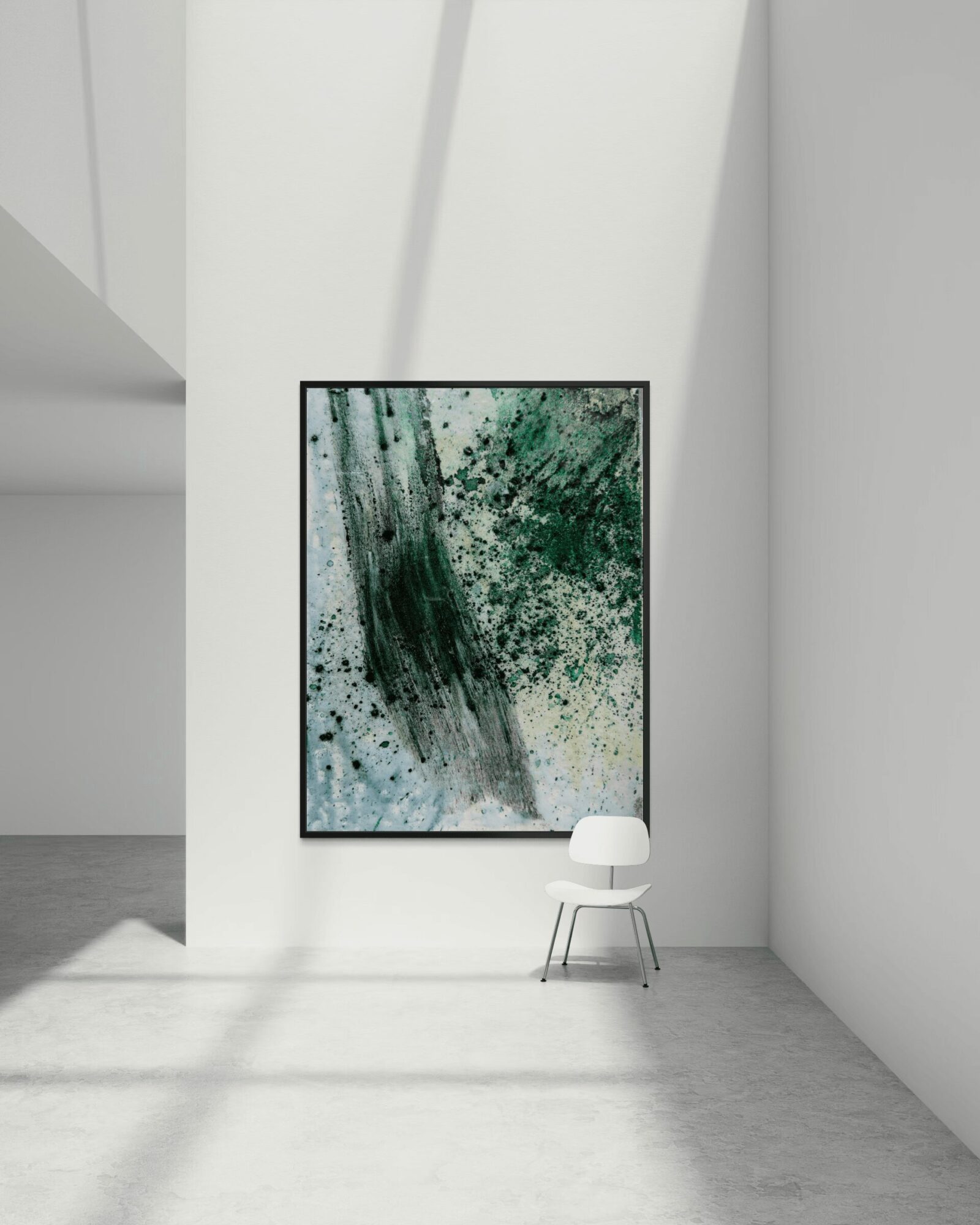 Abstract painting with green and black splashes hangs on a white wall, with a white chair below it.