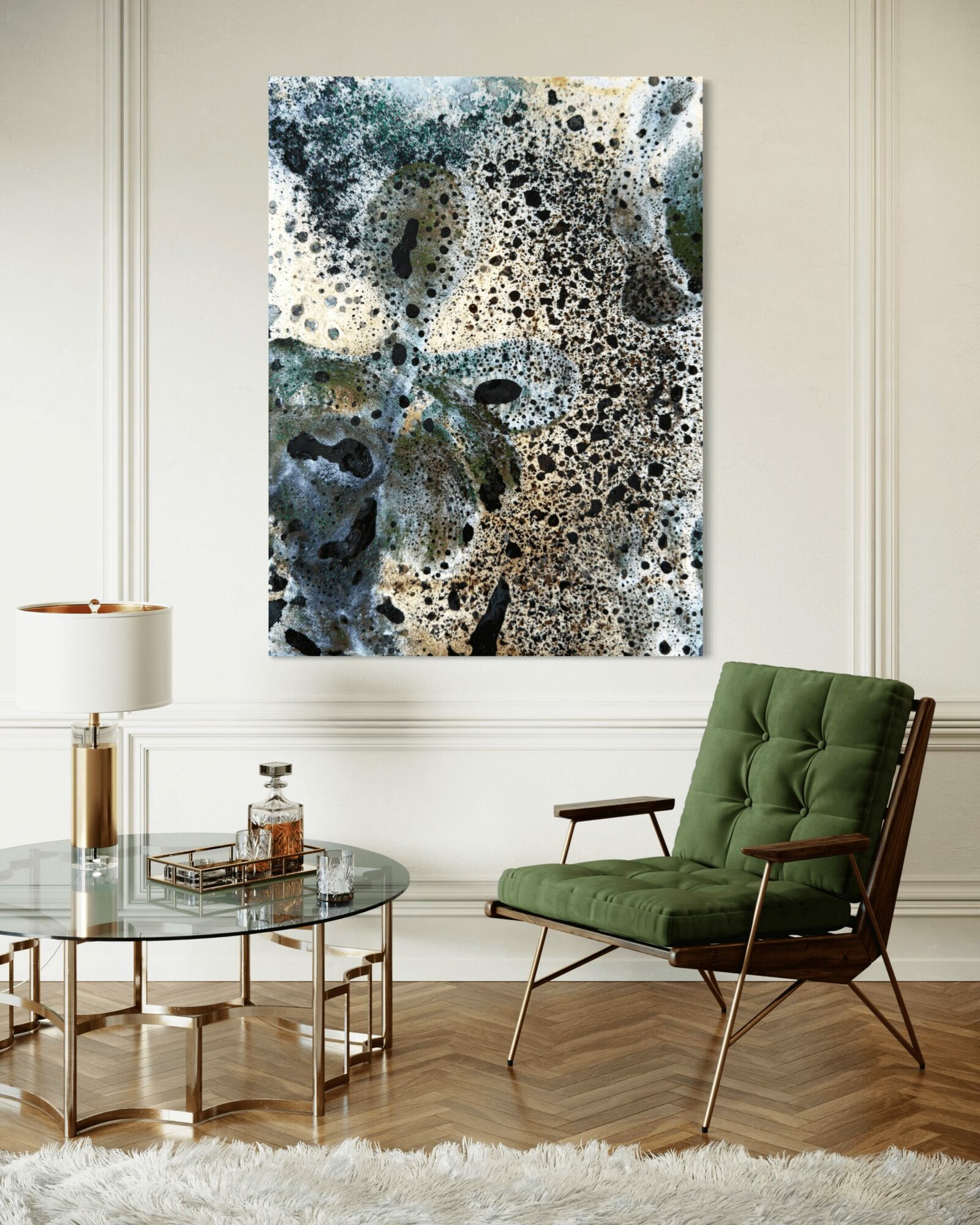 Abstract artwork with black, white, and green splashes hangs on a white wall in a living room.