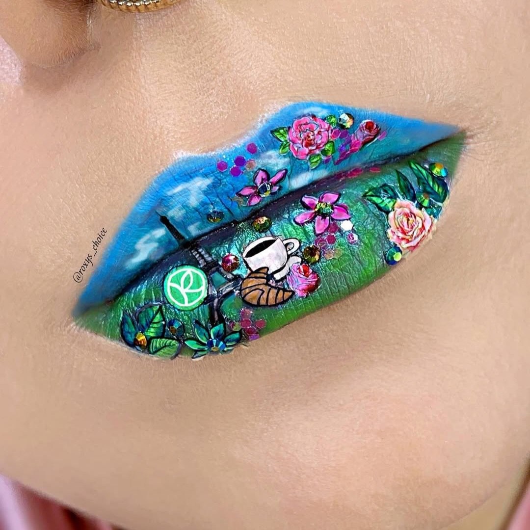 Lips painted with colorful floral and nature-themed design, including flowers, a teacup, and a butterfly.