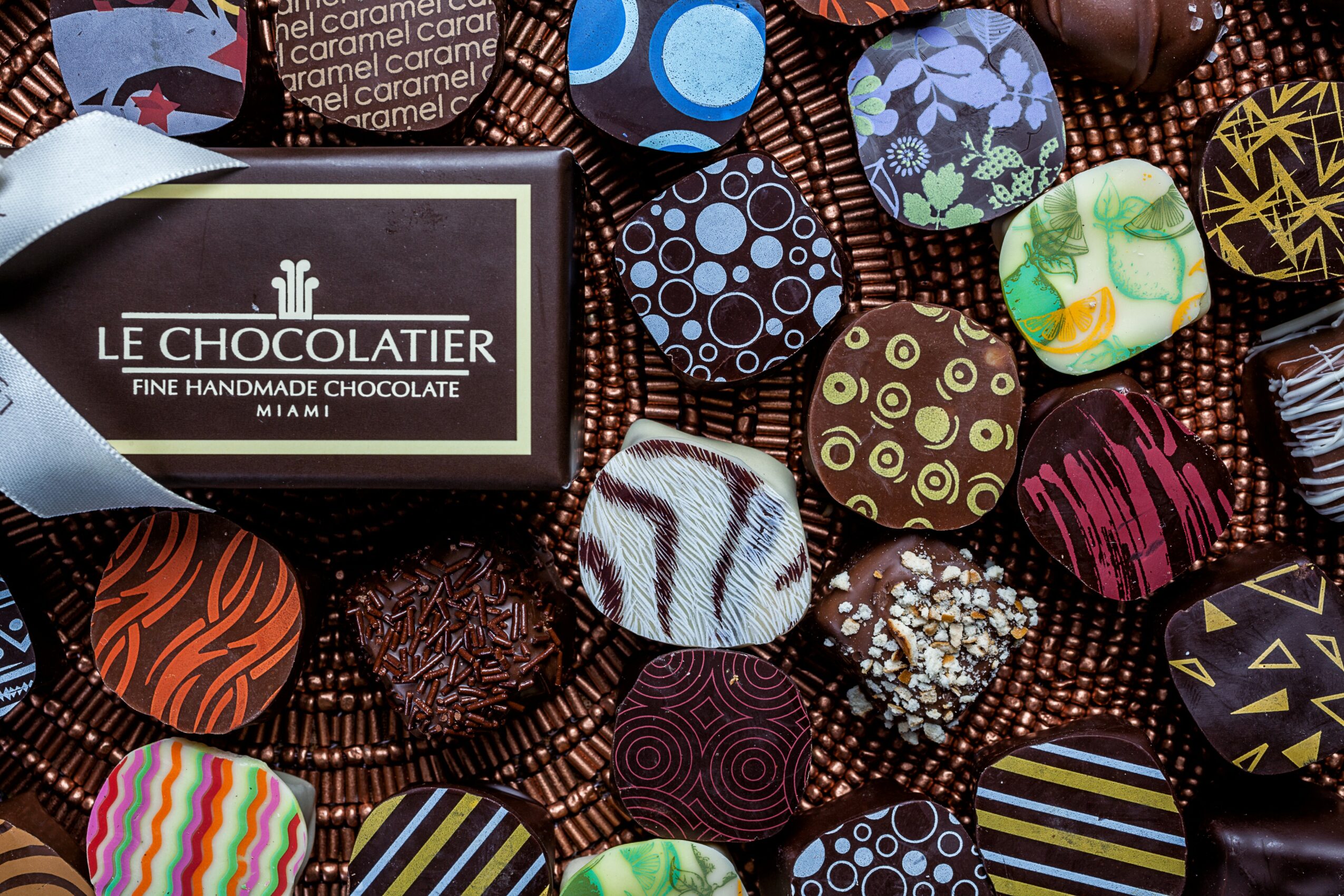Assorted colorful chocolates with various patterns and wrappers on a wire basket.