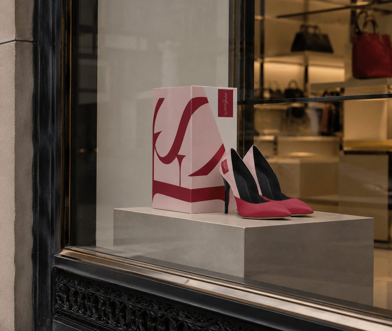 Black and pink high-heeled shoes displayed on a window ledge with a shopping bag behind them.