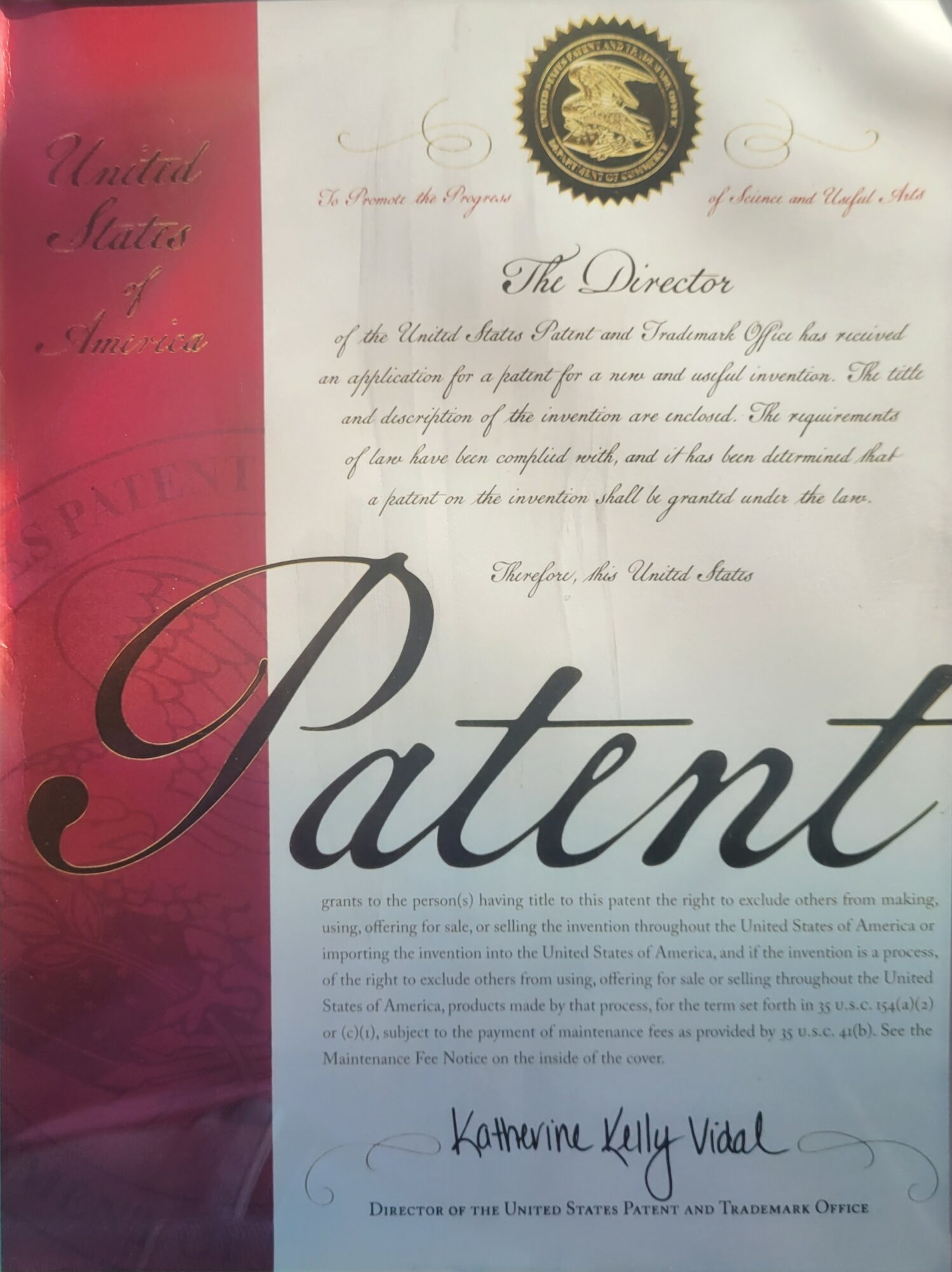 Official document with a gold seal, red and white background, and large cursive text reading 'Patent'.