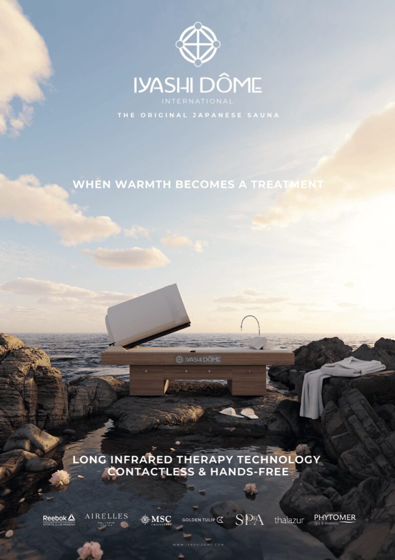 A wooden therapy bed on rocks by the sea with a sunset sky, promoting infrared therapy technology, contactless and hands-free.