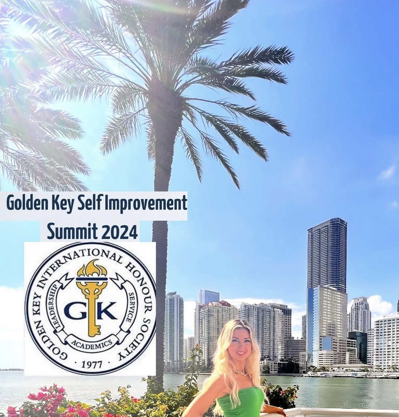 A woman with long blonde hair smiling outdoors with a city skyline and palm tree in the background.