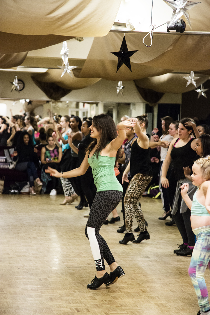 Group of people dancing in a decorated indoor space with star decorations hanging from the ceiling.