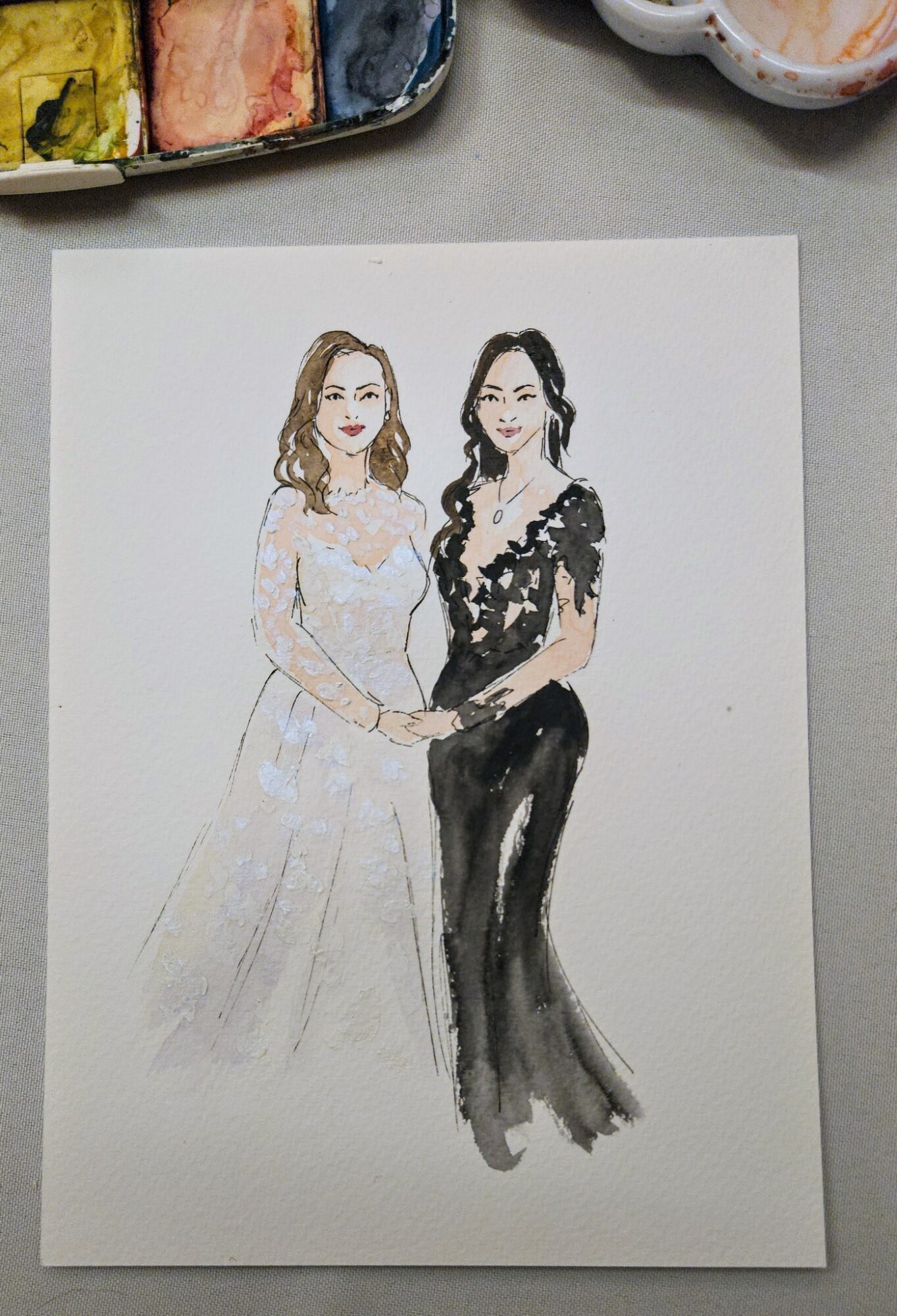 Watercolor illustration of two women standing side by side, one in a light dress and the other in a dark gown.