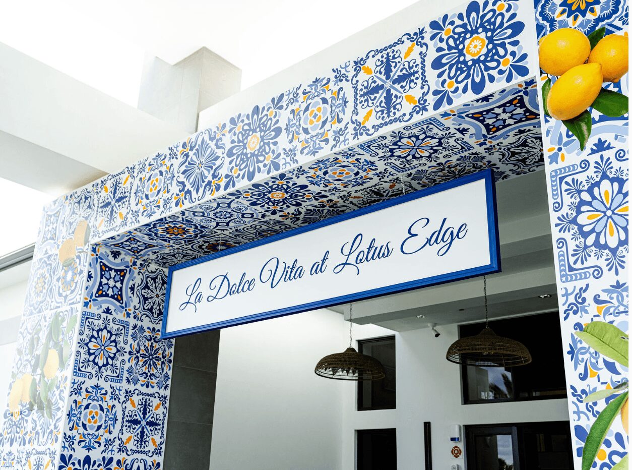 Sign reads 'La Dolce Vita at Lotus Edge' with decorative blue and white tile patterns above and around it.
