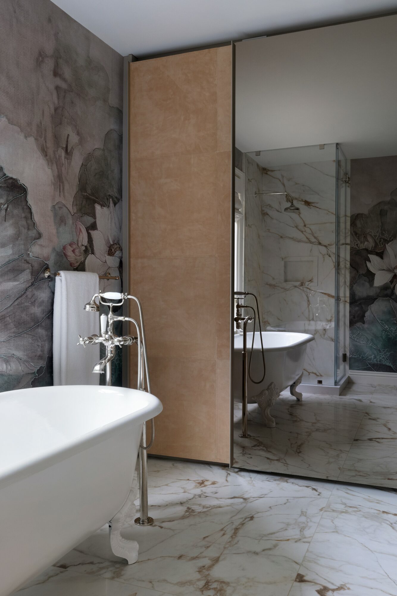 Bathroom with bathtub, sink, mirror, and marble walls and floor, partially visible shower area, and a large mirror.