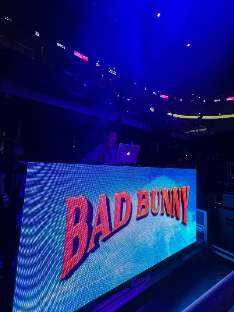 A digital display shows the words 'BAD BUNNY' in bold red letters on a blue background.