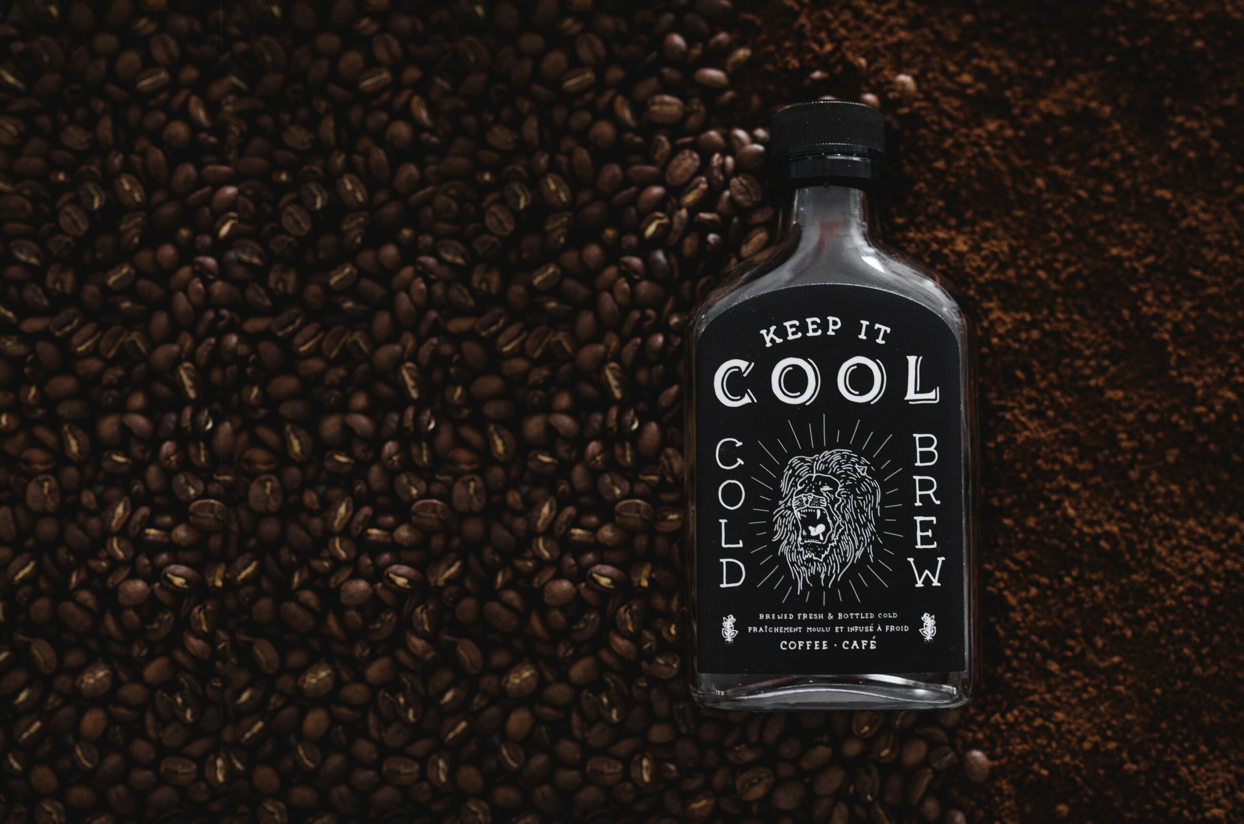 Bottle labeled 'Keep It Cool' surrounded by coffee beans, with a lion illustration on the label.
