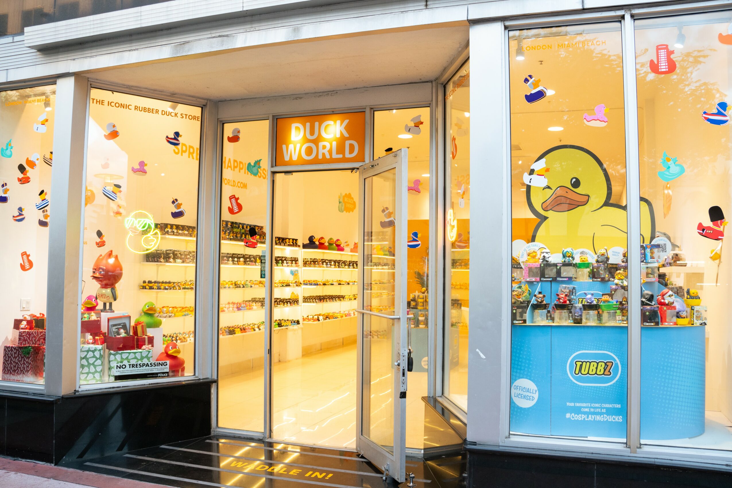 Storefront with large duck-themed decorations, shelves with products, and a bright yellow sign reading 'DUCK WORLD'.