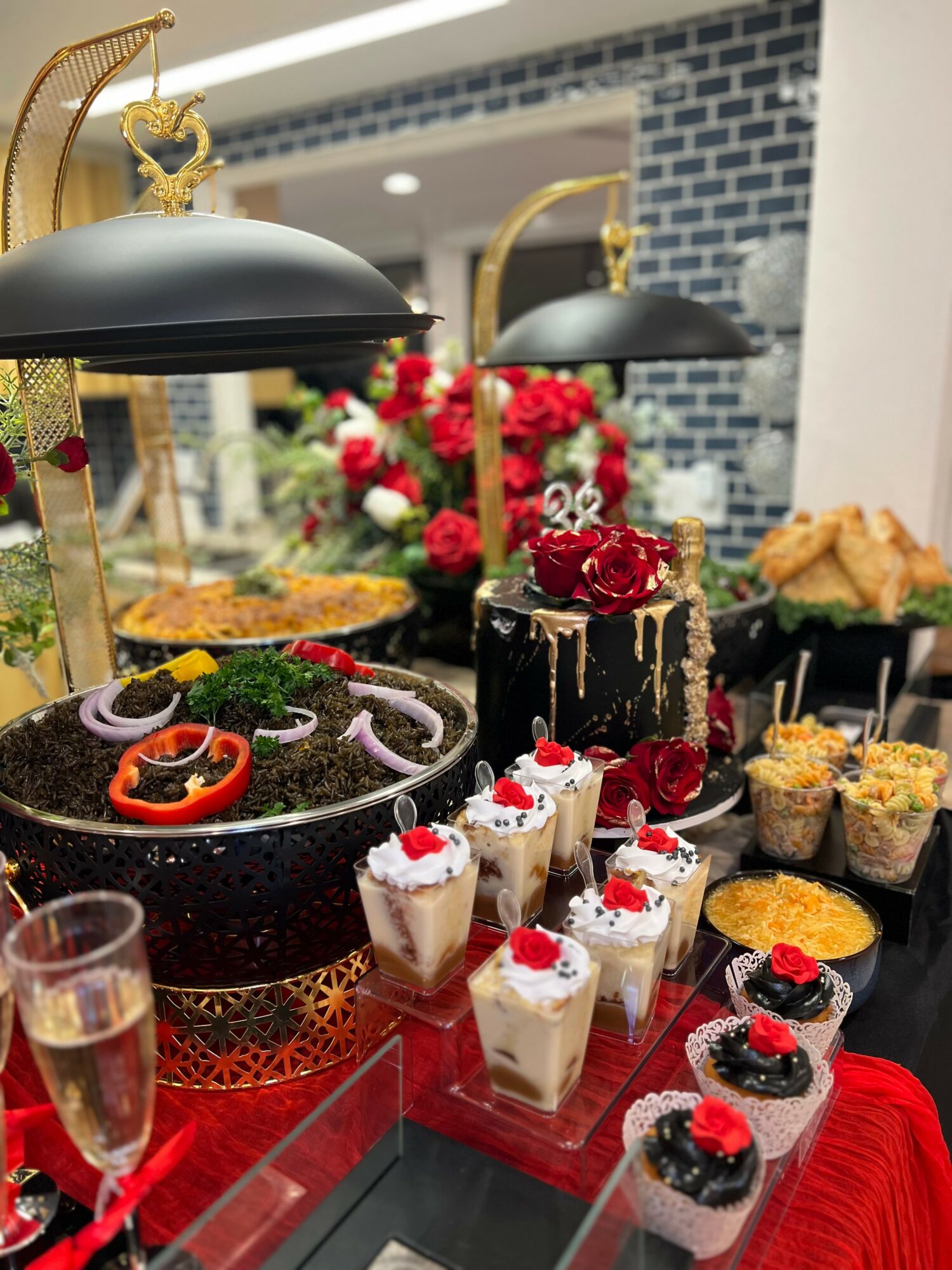 Display of desserts including cupcakes, cakes, and pastries with flowers and decorative elements in a modern setting.