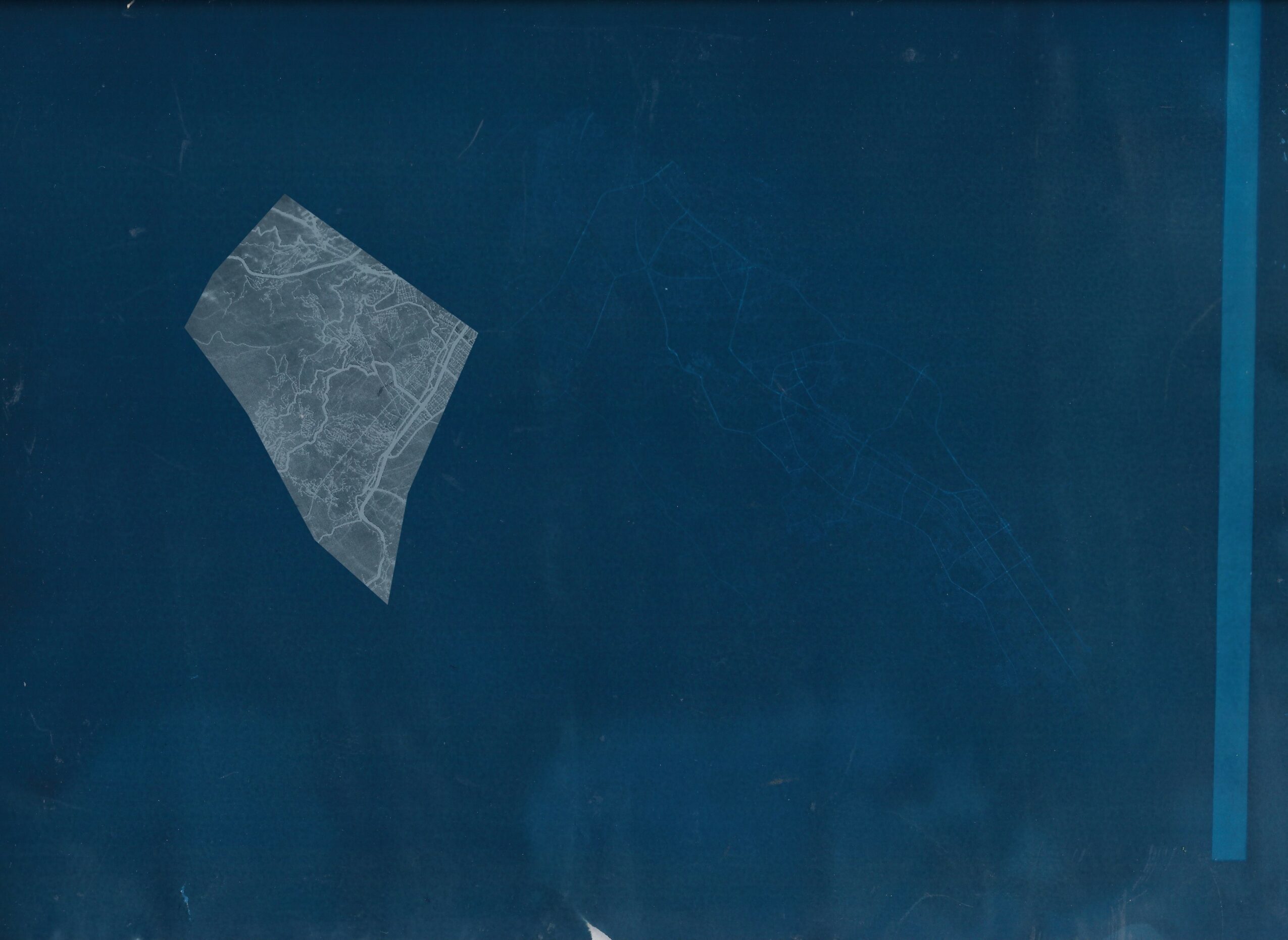 Blue surface with a piece of transparent tape attached, slightly tilted, and a faint vertical line on the right side.