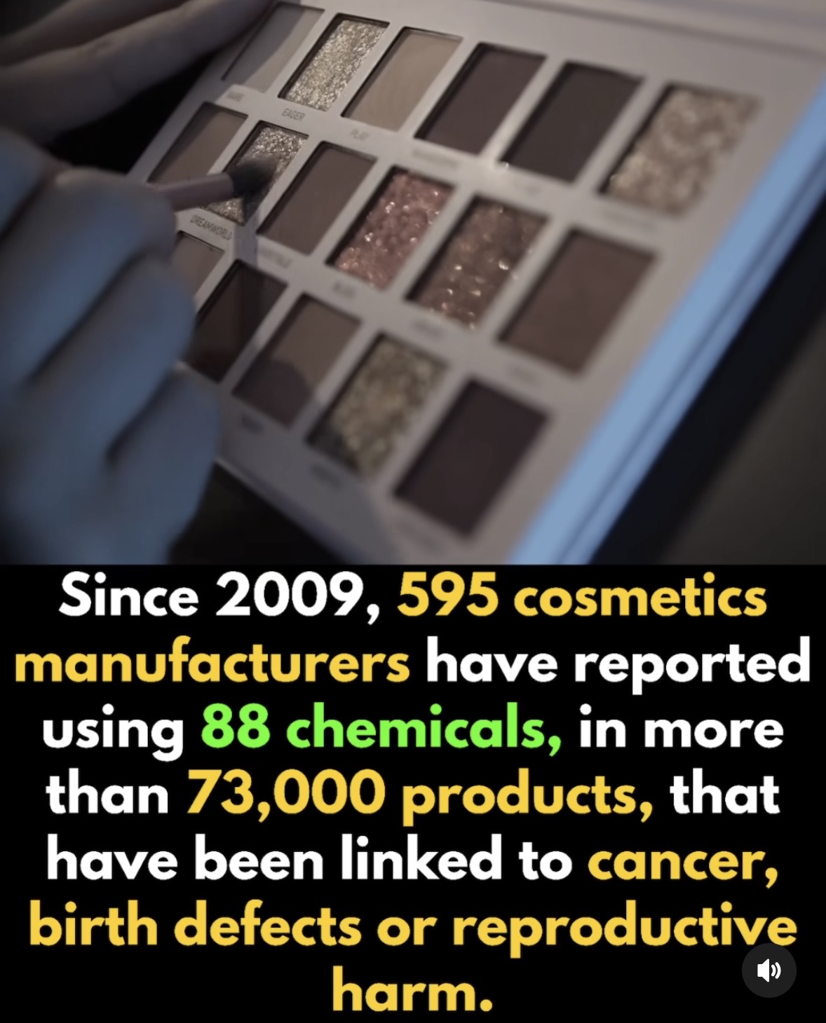Close-up of a hand holding a makeup brush over a palette of various cosmetics, including eyeshadows and powders.