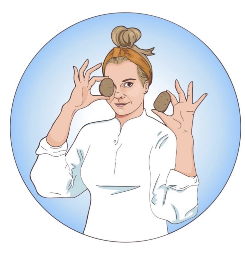 Woman with hair in a bun holding two cookies, one near her eye and one in her hand, against a blue background.