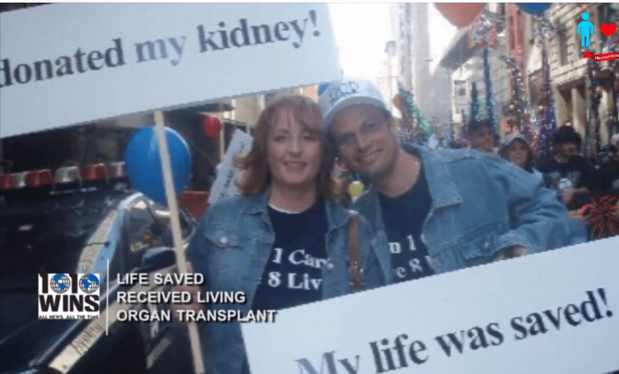 Two people smiling holding signs about organ donation in a busy street, with text about a kidney donation and life saved.