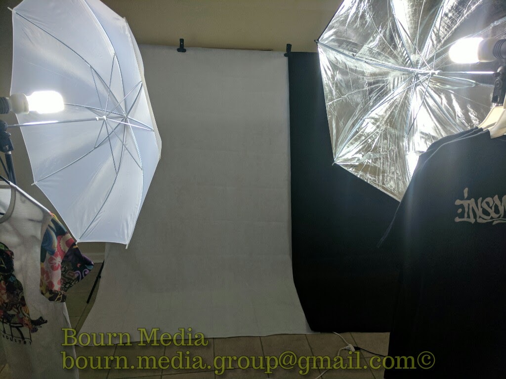 Studio setup with two large umbrellas and a backdrop, used for photography or filming.