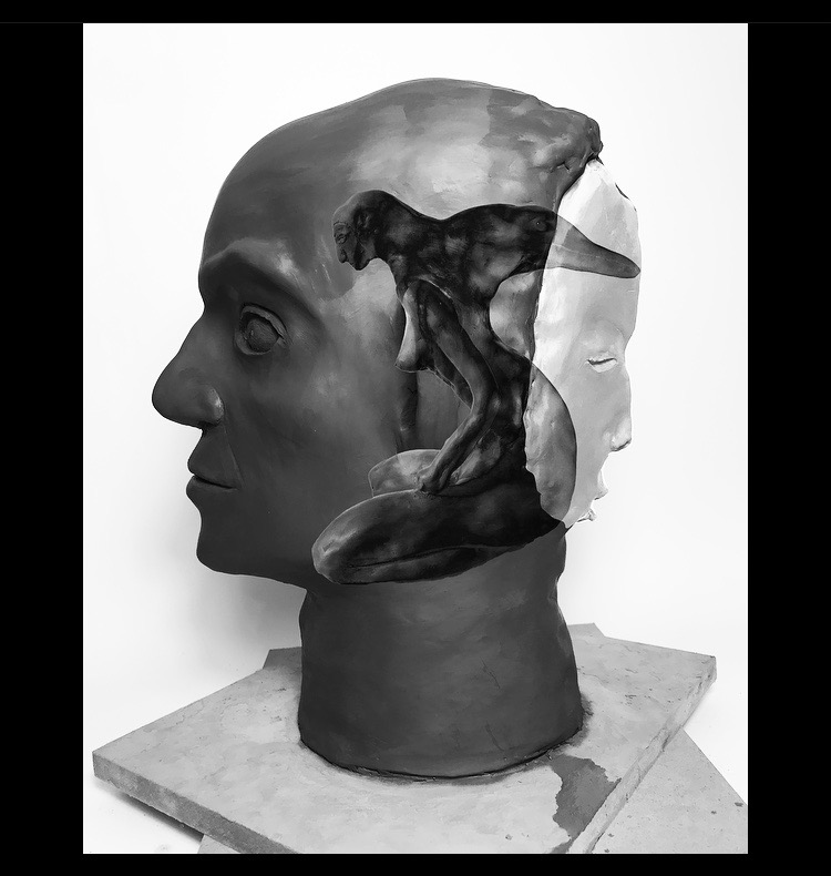 A sculpture of a human head with a cutaway revealing an inner face and abstract shapes inside.