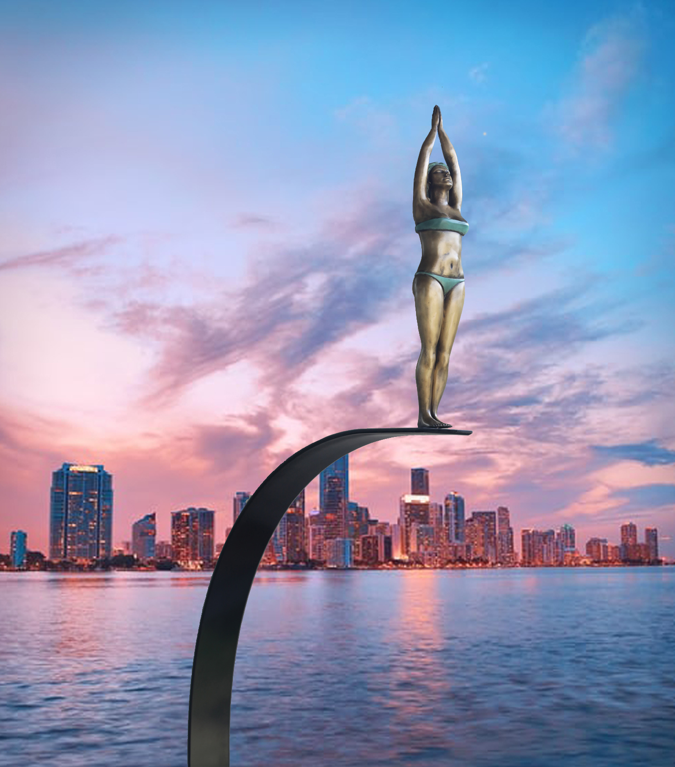 Statue of a woman with arms raised, standing on a curved black structure against a city skyline at sunset.