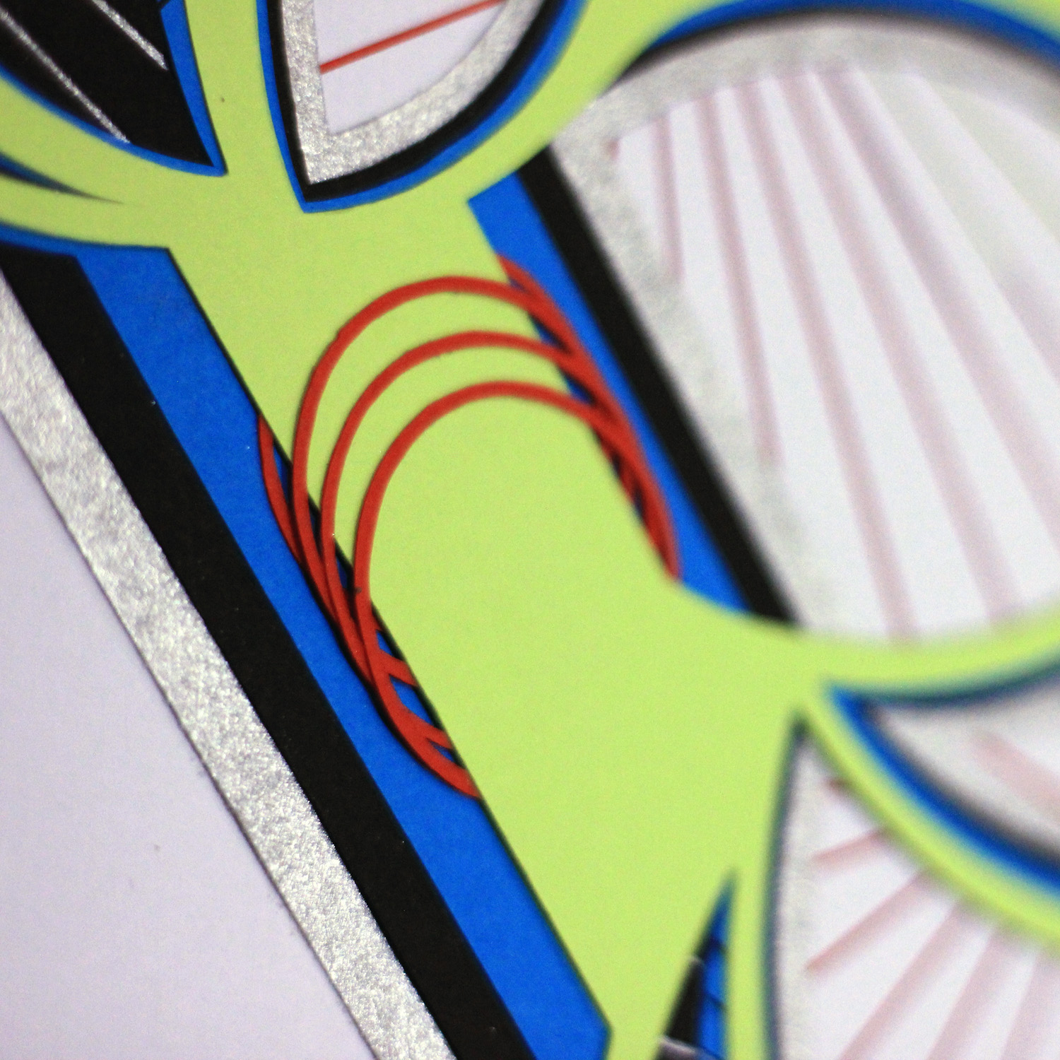 Close-up of a colorful, abstract design with green, blue, and red elements, and a textured background.