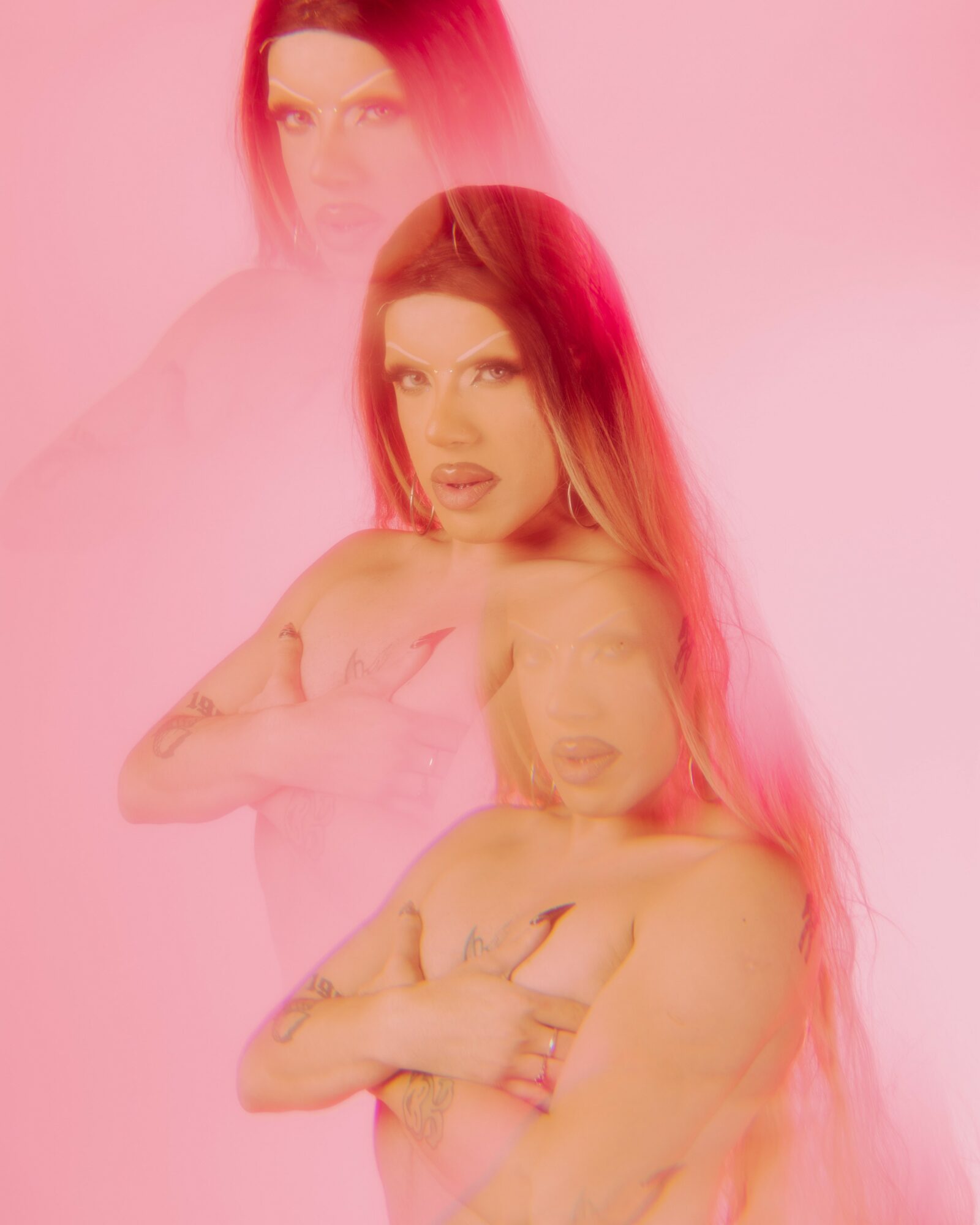 A woman with long hair poses with crossed arms, multiple overlapping images create a layered effect, pink background.