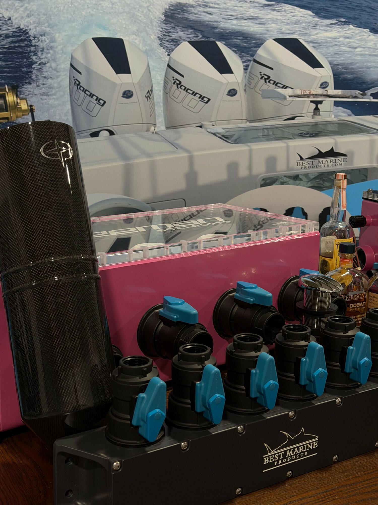 Multiple camera lenses and equipment on a table with boats in the background, viewed from the side.