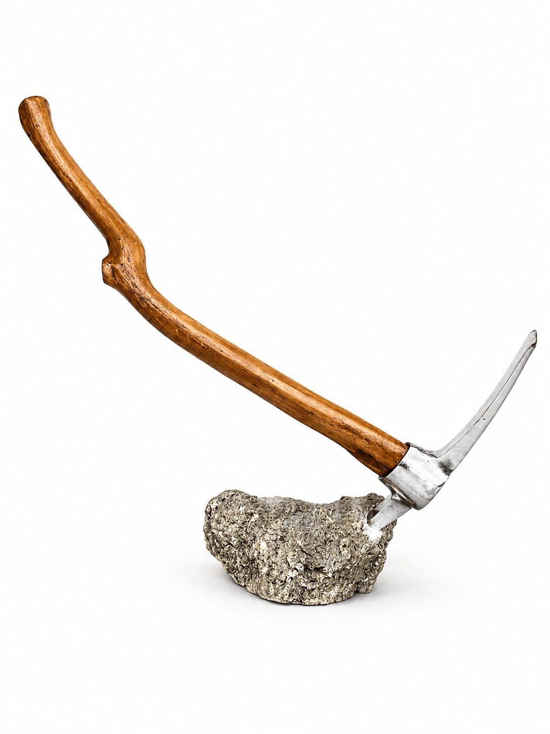 A pickaxe with a wooden handle and metal head embedded in a rock, against a white background.
