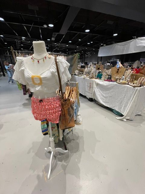 Cleaning supplies and cloths on a cart in a store, with shelves and products in the background.