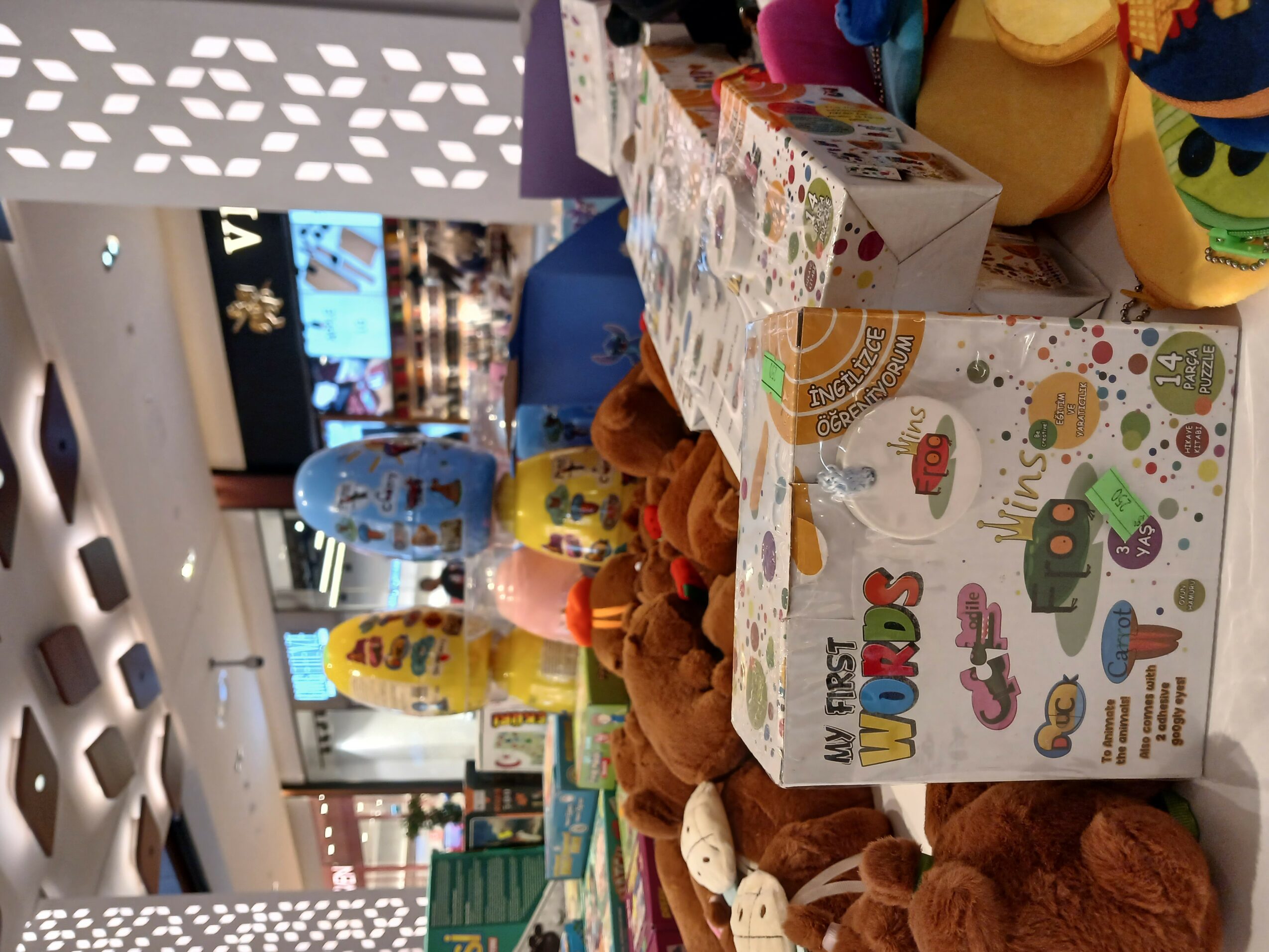 Display of toys and snacks on a store shelf with colorful packaging and plush toys.