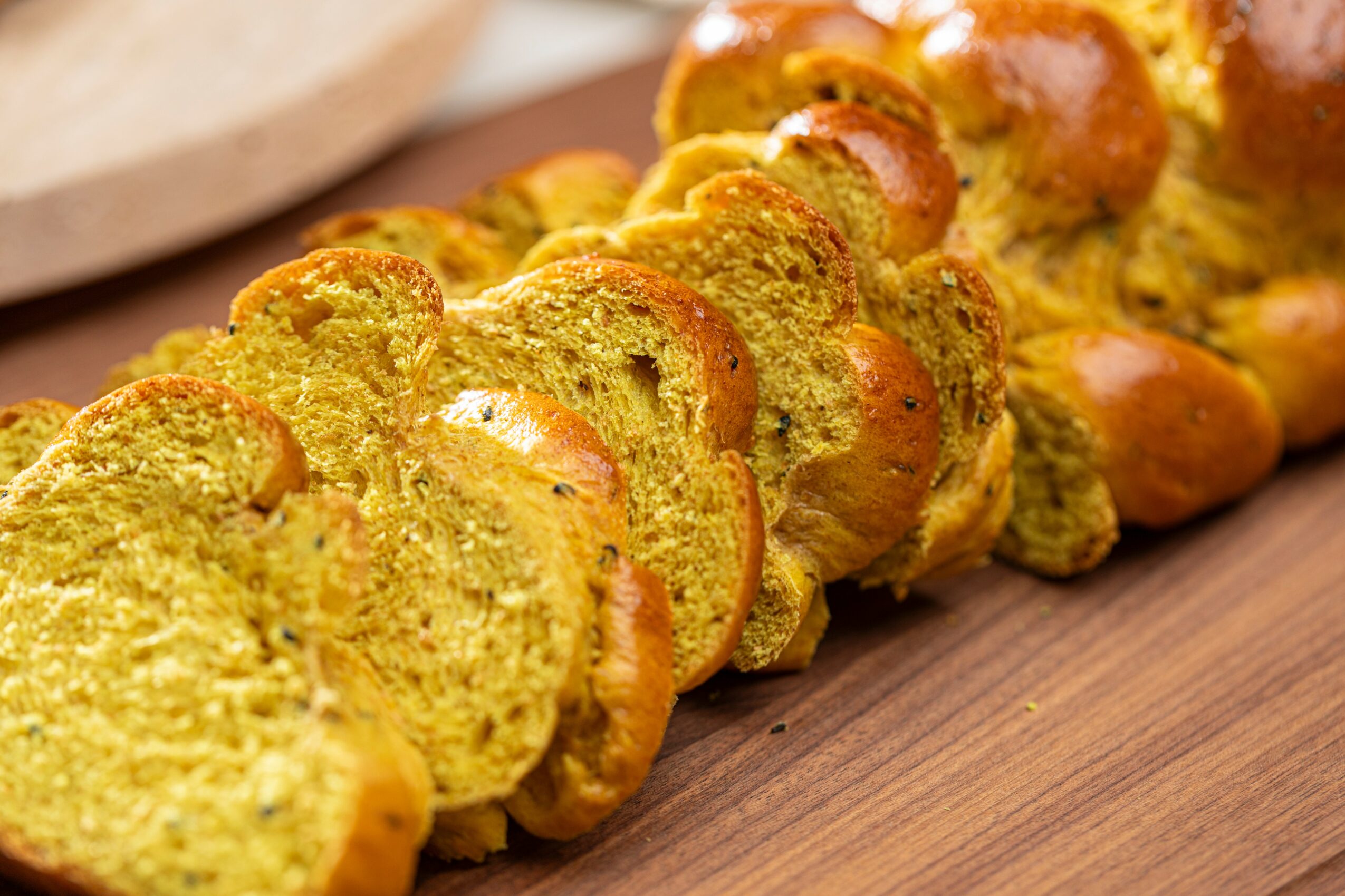 Slices of greenish bread with a soft interior and golden crust arranged on a wooden surface.