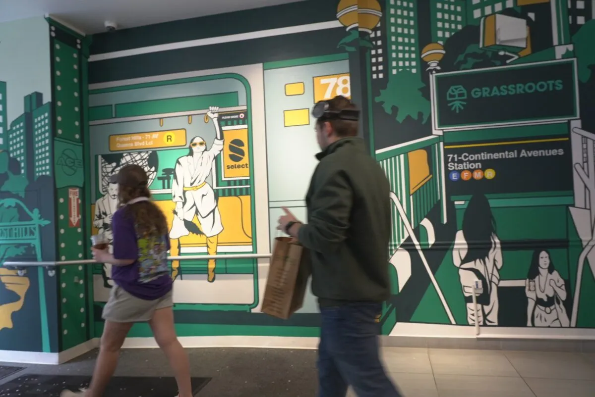 People walking past a colorful mural of a subway station with trees and cityscape in the background.