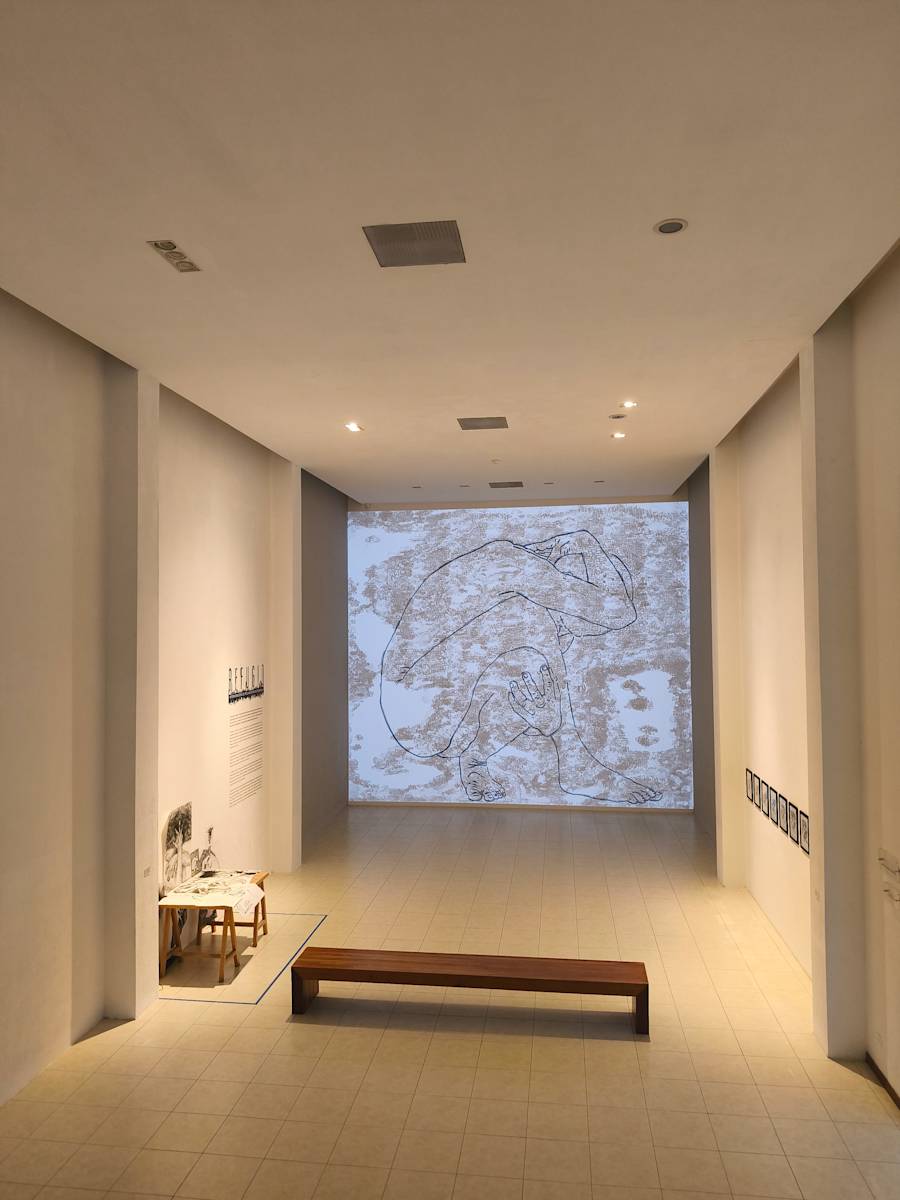 Empty room with a large window showing a snowy landscape, a bench, and minimal furnishings.