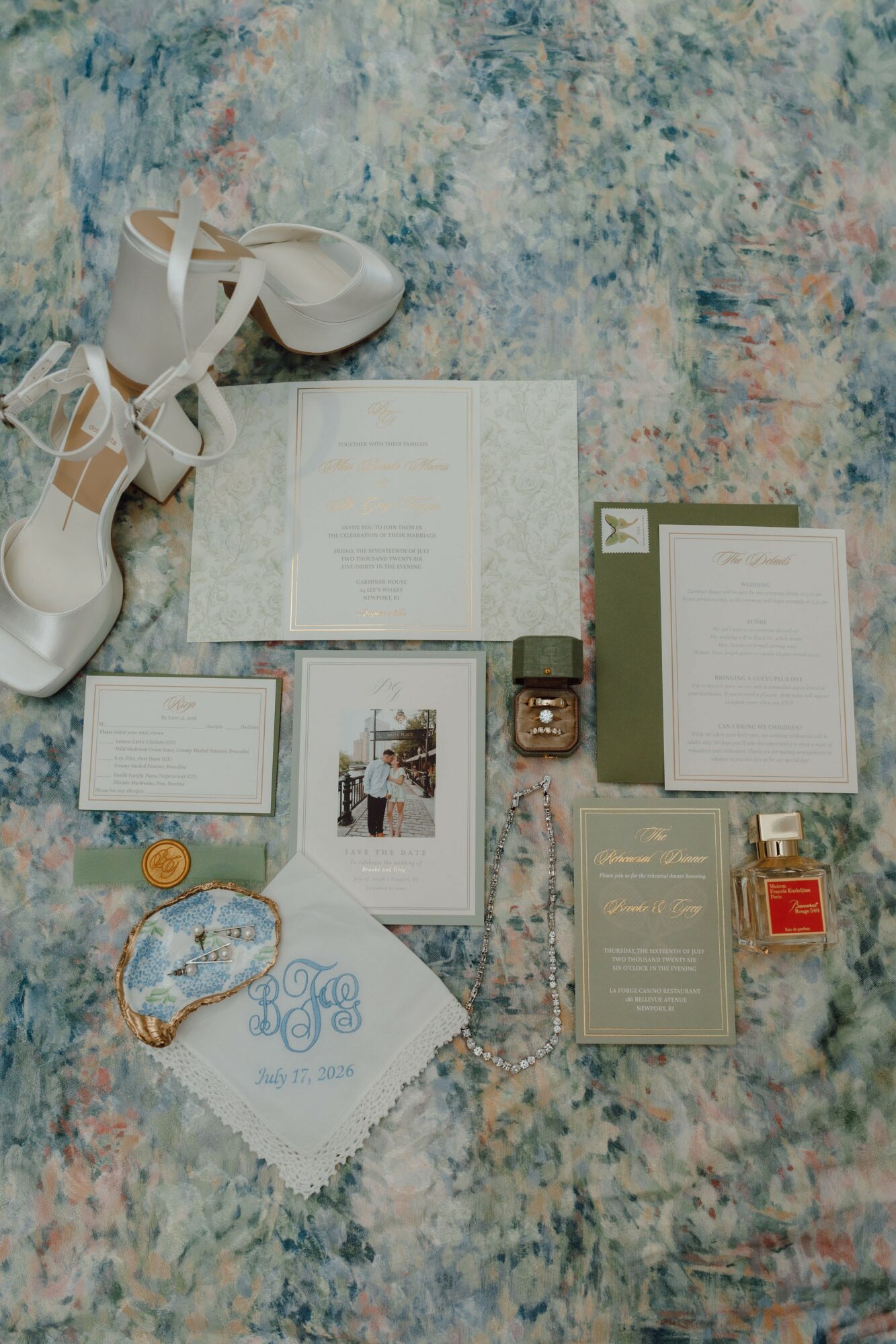 Flat lay of shoes, documents, jewelry, and perfume bottles on a textured surface.