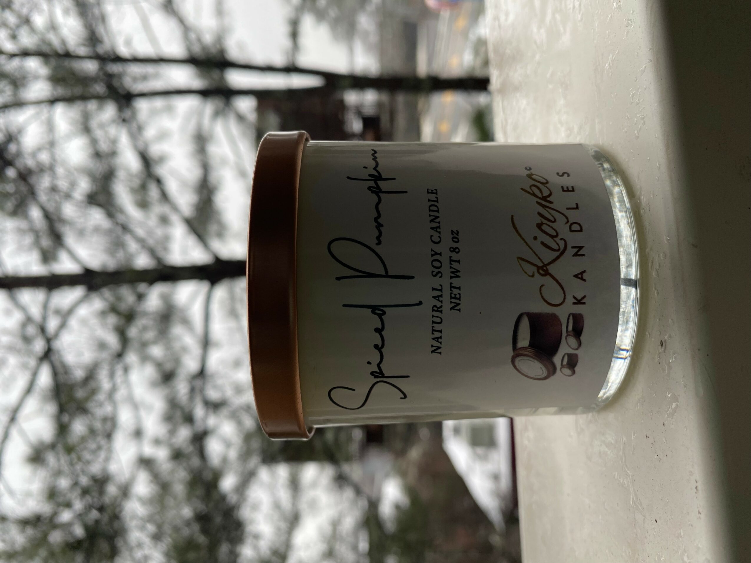 A white candle jar with a rose gold lid, labeled 'Soul Purpose' and 'Kiehl's' on a white surface.